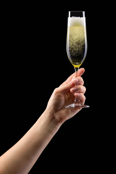 Woman hand holding glass of sparkling champagne isolated on black. — Zdjęcie stockowe