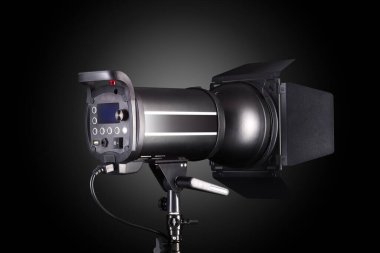Photography studio flash isolated on black background with lamp.