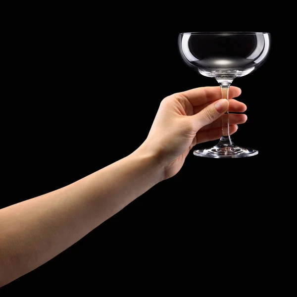 Woman hand holding empty glass of champagne isolated on black. — Stockfoto