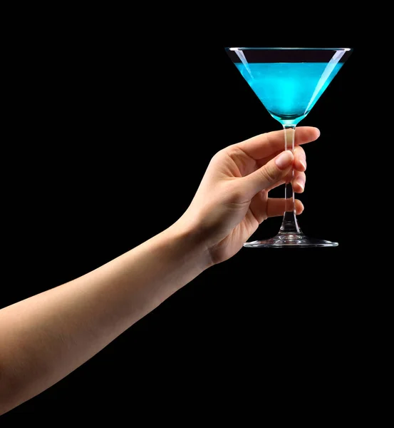 Mano de mujer sosteniendo vidrio de martini azul aislado en negro . — Foto de Stock
