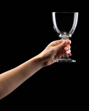 Woman hand holding empty beer glass isolated on black.