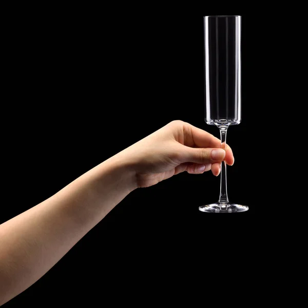 Woman hand holding empty glass of champagne isolated on black. — Zdjęcie stockowe