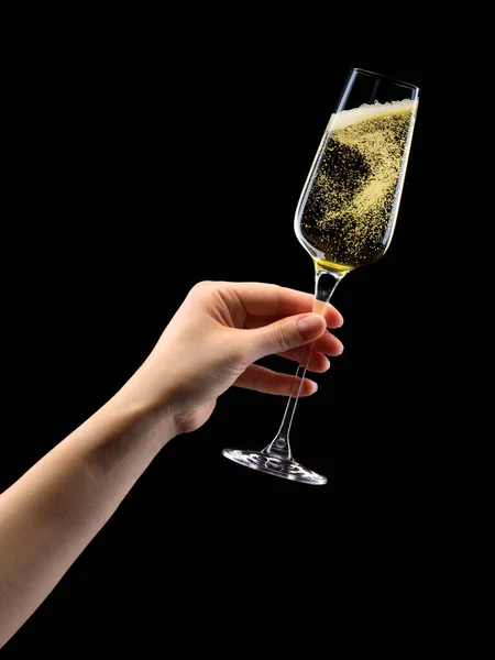 Woman hand holding glass of sparkling champagne isolated on black. — Stockfoto