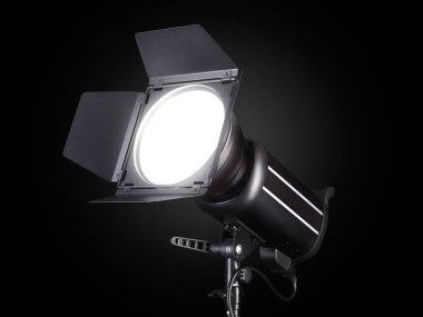 Photography studio flash isolated on black background with lamp.