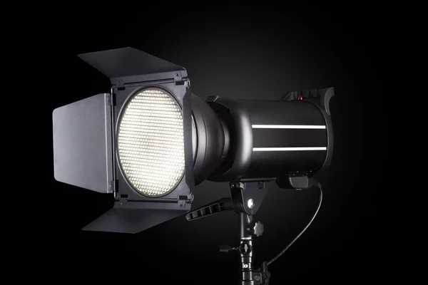 Photography studio flash isolated on black background with lamp.