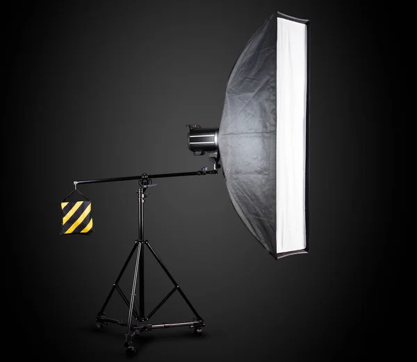 Fotostudio verlichting tribunes met flitser en softbox geïsoleerd op het zwart. — Stockfoto