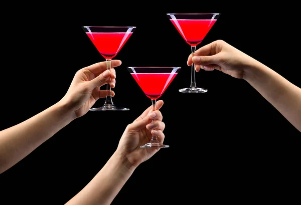 Ensemble de mains tenant le verre de martini aux fraises isolé sur noir . — Photo