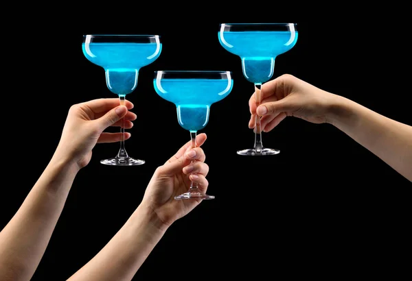 Set of hands holding blue curacao margarita glass isolated on black. — Stock Photo, Image