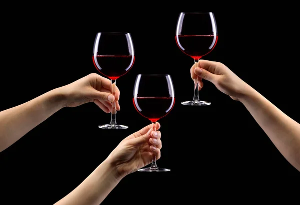 Set di mani che tengono il bicchiere di vino rosso isolato su nero . — Foto Stock