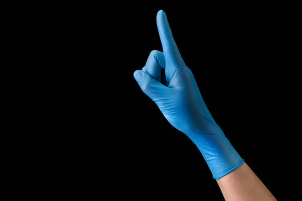 Doctors hand in sterile medical gloves pointing up isolated on black — Stock Photo, Image