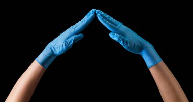 Doktorlar steril tıbbi eldivenler veriyorlar. Siyah üzerinde kalp şeklinde izole edilmiş.