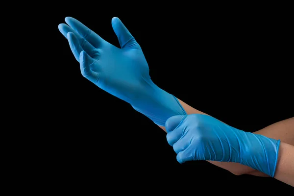 Doctor wearing a medical glove on hands isolated on black — Stock Photo, Image