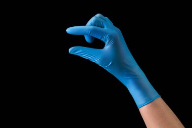Doktor 'un eli steril tıbbi eldivenlerle siyah arka planda kesme yolu olan iki parmağı olan bir şey tutuyor. Salgın ve virüslere karşı korunma kavramı.