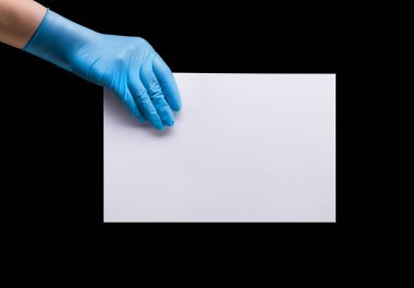 Doktor 'un eli steril tıp eldivenlerinde pankart tutarken siyah arka planda kırpma yolu ile izole edilmiş. Salgın ve masaja karşı korunma kavramı Evinizde kalın.