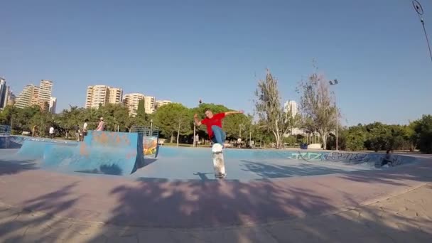 Мальчик летал на скейтборде в скейтпарке — стоковое видео