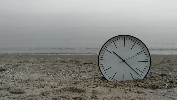 Zaman kavramı arka plan, beyaz duvar saati w siyah kum plaj deniz okyanus okları — Stok video
