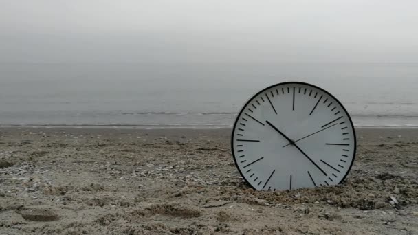 Fondo de concepto de tiempo, Reloj de pared blanca w Flechas negras en arena playa mar océano — Vídeo de stock