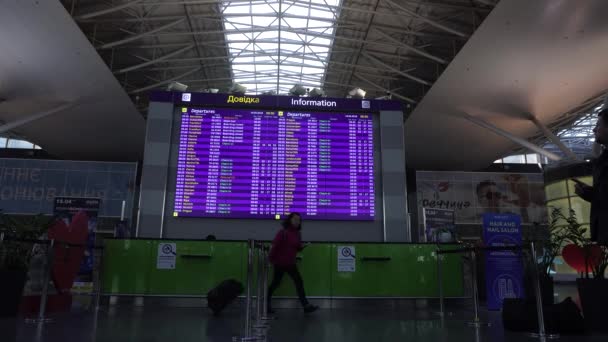 Flughafen Boryspil, Kyiw, Ukraine: Passagier beobachtet Flugplan Abflug Ankunft im Terminal — Stockvideo