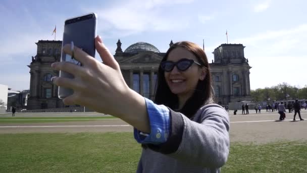 Glückliche reiselustige frau beim videoanruf auf smartphone, reichstagsgebäude, berlin — Stockvideo