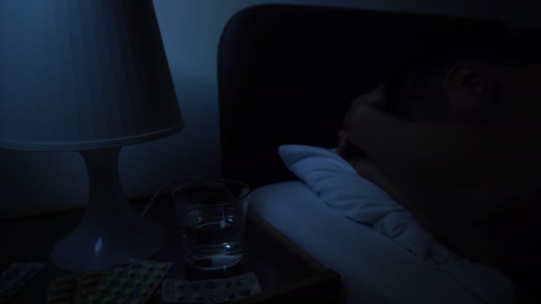 Человек спит плохо в постели ночью, страдает от бессонницы головной боли болезни — стоковое видео