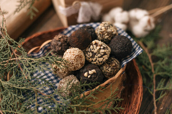 Decorative composition with chocolate candies on checkered napkin and coniferous twig.