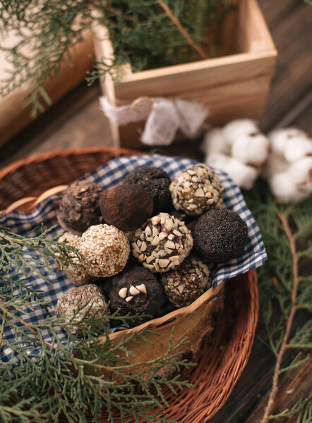 Decorative composition with chocolate candies on checkered napkin and coniferous twigs