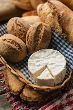 Taze somun ekmek ve ahşap masa üzerinde hasır sepet içinde ev yapımı peynir pişmiş Delicious
