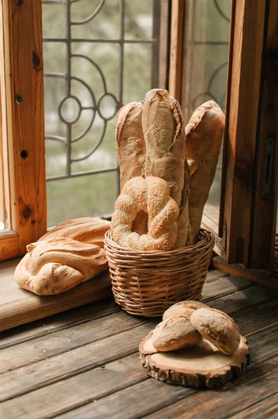 おいしい焼きたての窓辺に枝編み細工品バスケットのパンのパン — ストック写真