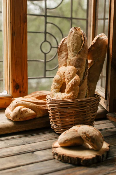 Pyszne Świeżo Pieczone Bochenków Chleba Wiklinowym Koszu Parapety Drewniane — Zdjęcie stockowe