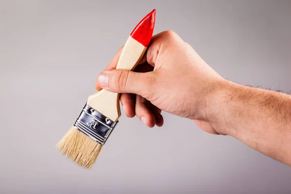 Bir boya fırçası tutan el — Stok fotoğraf