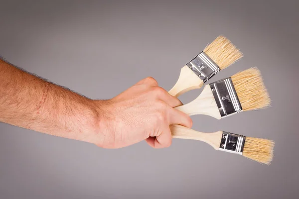 Mão segurando Pincéis — Fotografia de Stock