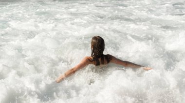 Kız dalgalar üzerinde eğlenceli yaşıyor, dalgalar köpük 