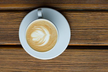 ahşap masa üzerinde köpük ile beyaz fincan kapuçino 