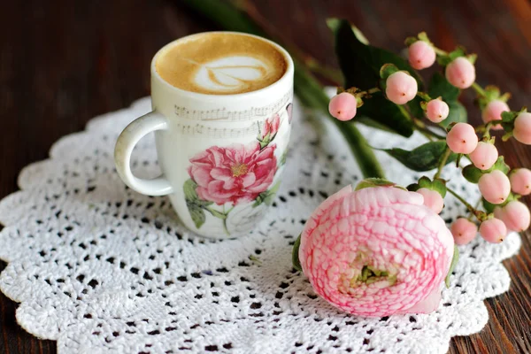 Cappuccino in de vintage cup met ontwerp met bloemen en gebreide servet — Stockfoto