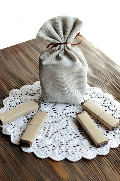 small fiber pouch for present on wooden table with chocolate on