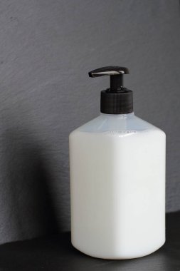 Bir şişe sabun, şampuan, duş jeli, antiseptik, dezenfektan ya da siyah taş desenli arka plan üzerindeki diğer dezenfektanlar, kopyalama alanı