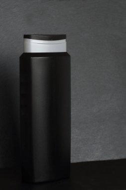 Bir şişe sabun, şampuan, duş jeli, antiseptik, dezenfektan ya da siyah taş desenli arka plan üzerindeki diğer dezenfektanlar, kopyalama alanı