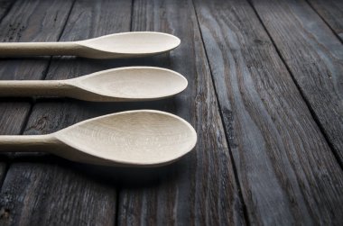 siyah ahşap zemin tahta kaşıklar içinde farklı baharatlar