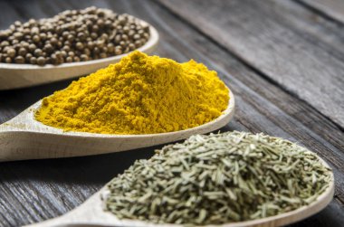 siyah ahşap zemin tahta kaşıklar içinde farklı baharatlar