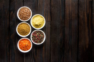 siyah ahşap zemin tahta kaşıklar içinde farklı baharatlar