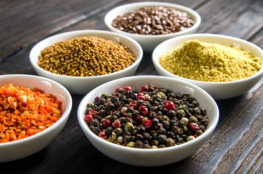 siyah ahşap zemin tahta kaşıklar içinde farklı baharatlar