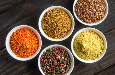 siyah ahşap zemin tahta kaşıklar içinde farklı baharatlar