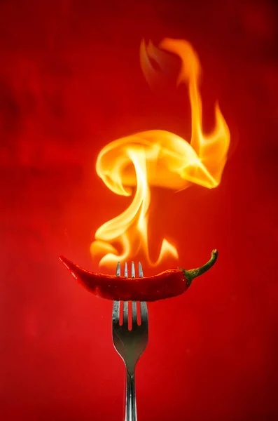 Peperoncino piccante rosso su fondo nero con fiamma — Foto Stock