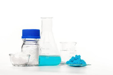 Beyaz laboratuvar masasında inorganik kimyasallar. Bakır (II) sülfat, mikro kristal cila, nikle klorür, alkol. Kozmetik ve Tuvalet malzemeleri için kimyasal malzeme.