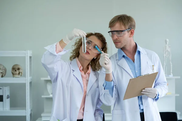 Genç bir Brezilyalı bilim adamı alkaliliğin asitliğini gözlemlemek için kimyasalların rengini düşünüyor. Ukraynalı bilim adamları dikkatli zehirli kimyasallar içeren test tüpleri tutuyorlar..