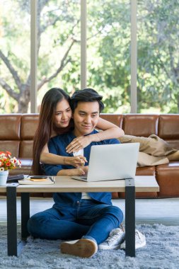 Genç aşıklar tatillerini birlikte oturma odasında geçirirler. Adam dizüstü bilgisayarın klavyesini yazarken ikisi de internet ürün bilgileriyle ilgileniyor..