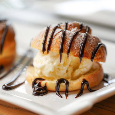 Profiterol, tipik olarak tatlı ve nemli vanilyalı dondurma, tuzlu karamel, çikolata soslu Fransız choux hamur topu.