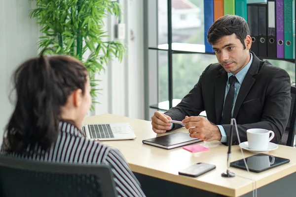 Young employers in black suits are evaluating job applicants by asking marketing strategy questions. Candidate didn\'t understand what the employer was trying to explain to her.