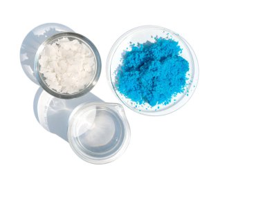 Beyaz laboratuvar masasındaki inorganik kimyasalları kapatın. Bakır (II) sülfat, deniz tuzu, alkol. Kozmetik ve Tuvalet malzemeleri için kimyasal malzeme. Üst Görünüm.