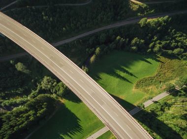 aerial view of empty bridge over beautiful green forest clipart